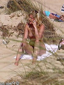 A mature woman feels that she is not being watched on a beach for nudists.