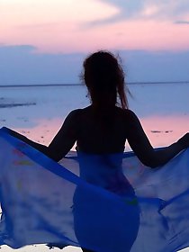 On sand seminude with light-color vase